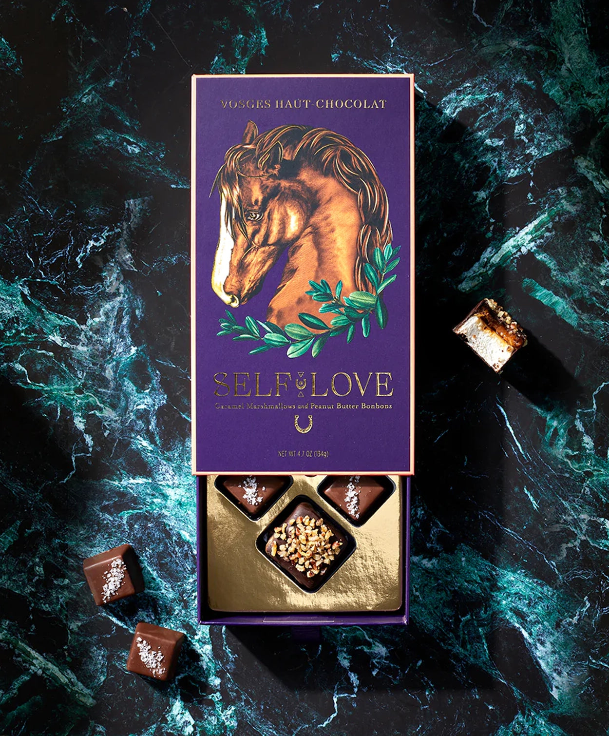 Vosges Self Love collection peanut butter bon bons caramel covered marshmallows on a marble countertop.
