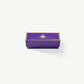 A small, rectangular purple chocolate candy box embossed with gold foil Vosges Haut-Chocolat logo sits closed on a grey background.