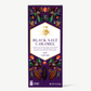Vosges Black Salt Caramel bar in box displaying colorful illustrations of salt crystals and cacao pods on a white background.