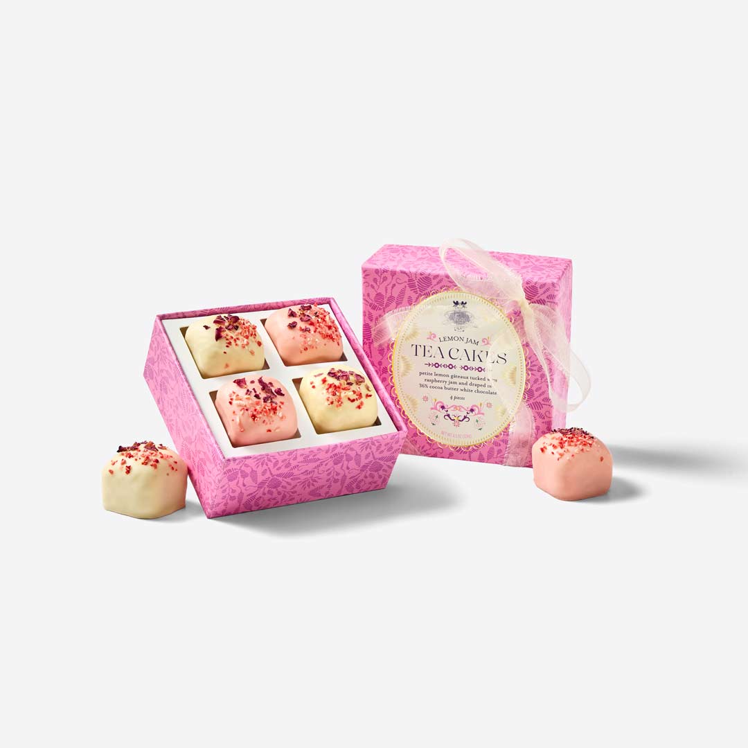 Pink tea cake boxes with treats on a white background