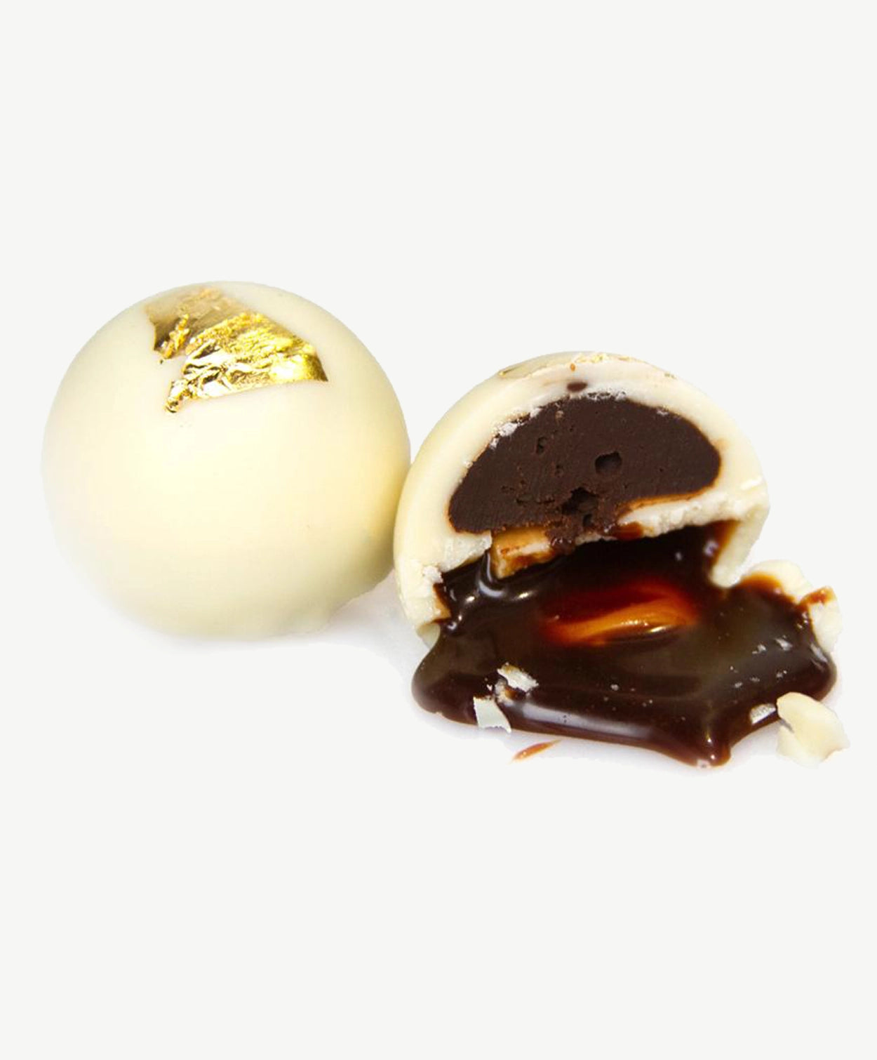Two Vosges Dalmore Scotch whisky truffles, cut in half revealing layers of eighteen year aged whiskey ganache and vanilla bean coffee burnt sugar caramel coated in white chocolate topped with gold leaf sits on a white background.