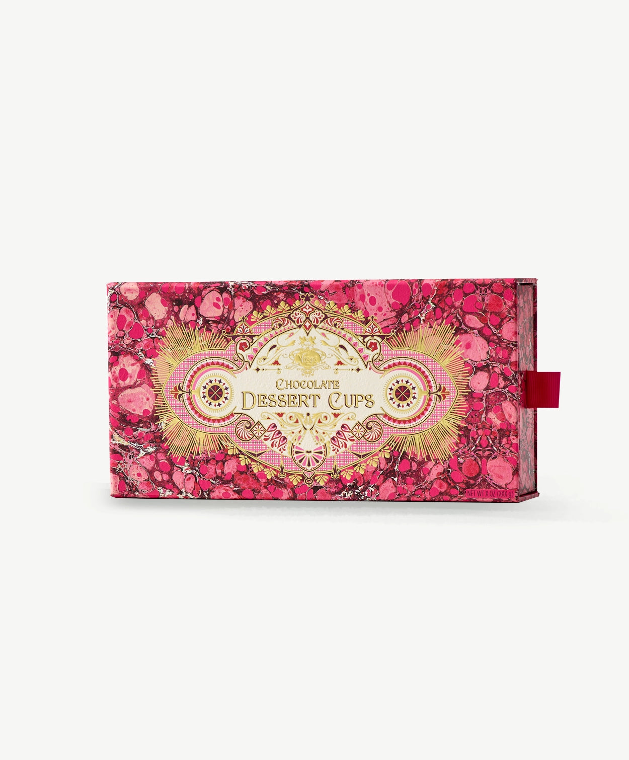 A pink and gold Vosges chocolate box with a red ribbon pull tab sits upright on a light grey background.