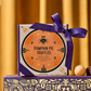 Gift box of Pumpkin Pie Truffles wrapped with a purple ribbon and orange round label