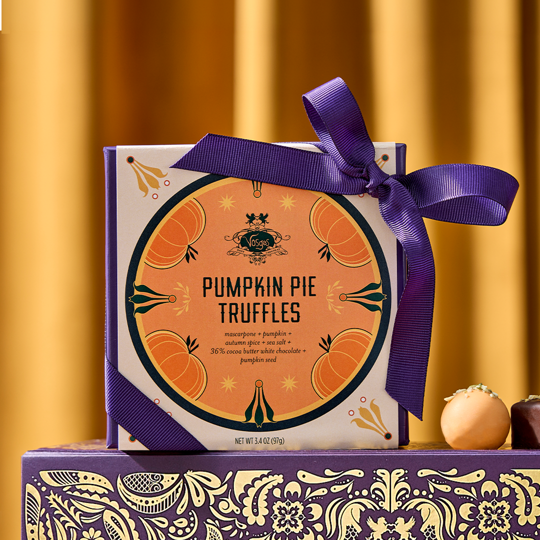 Gift box of Pumpkin Pie Truffles wrapped with a purple ribbon and orange round label