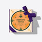 Overhead view of Pumpkin Pie Truffles box wrapped with a purple ribbon