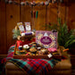 Hearthside S'mores Kit arranged on a wooden tray with graham crackers, marshmallows, and chocolate set on a plaid blanket.
