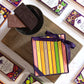 Vosges Mini Chocolate Bar Library and two bars of chocolate sit on an antique book surrounded by mini chocolate bars on a marble table top.