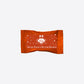 Spiced Peanut Butter Bonbon wrapper in orange with white crest and star motifs.