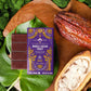 Vosges Whole Cacao Fruit Pure Plant Bar on a large green leaf beside an opened cacao pod surrounded by green moss.