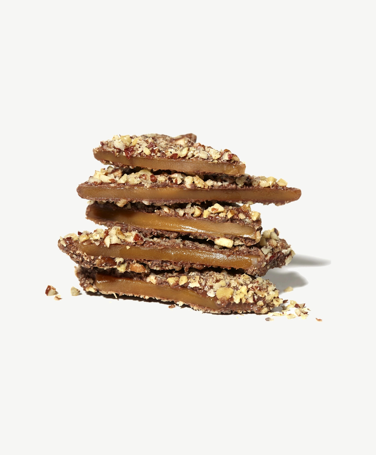 Close-up stack of Vosges Caramel Toffee  coated in milk chocolate and crushed nuts on a white background.  