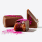 Close up of pink dusted Vosges chocolates on a white background