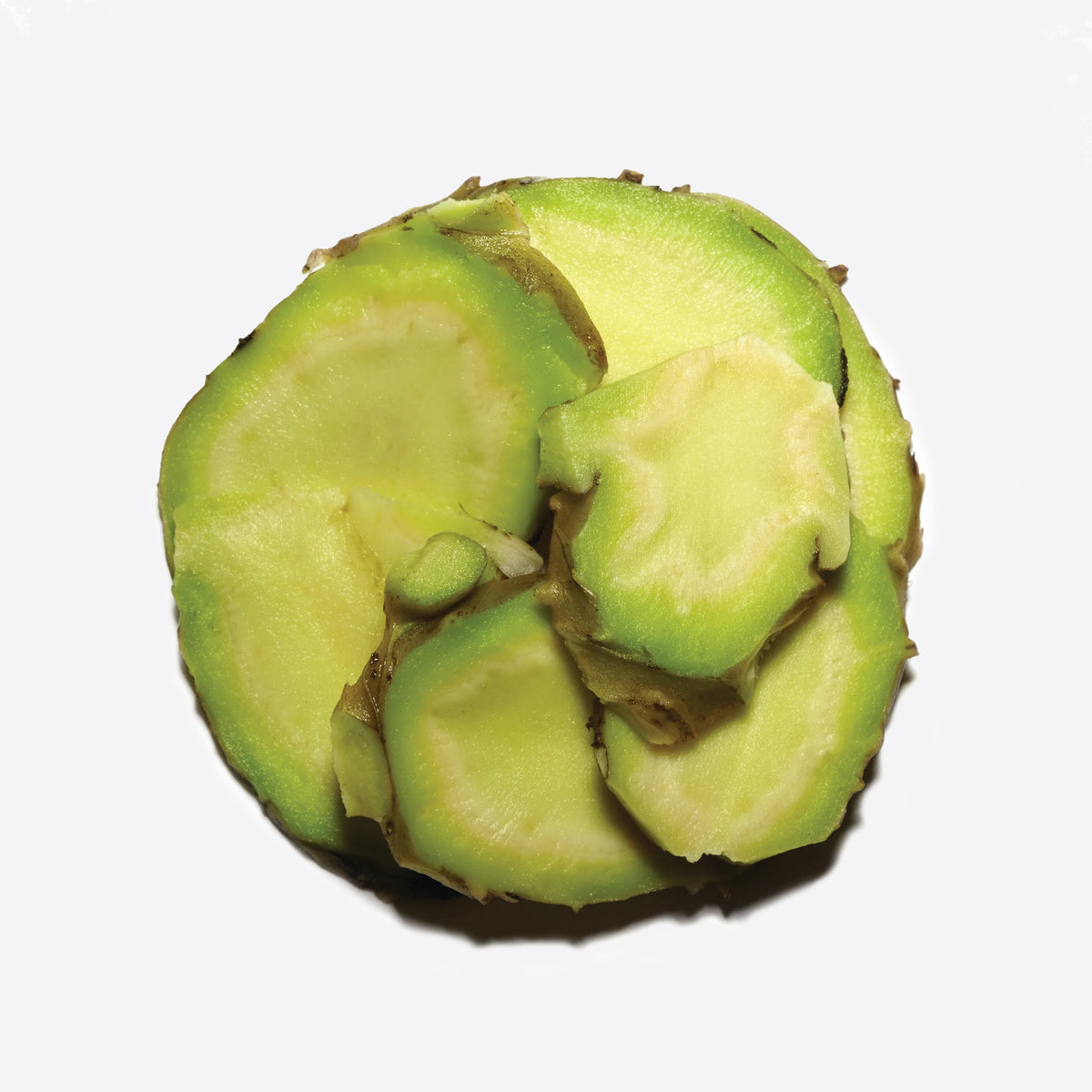 Close-up of a green kiwi slice with brown skin edge