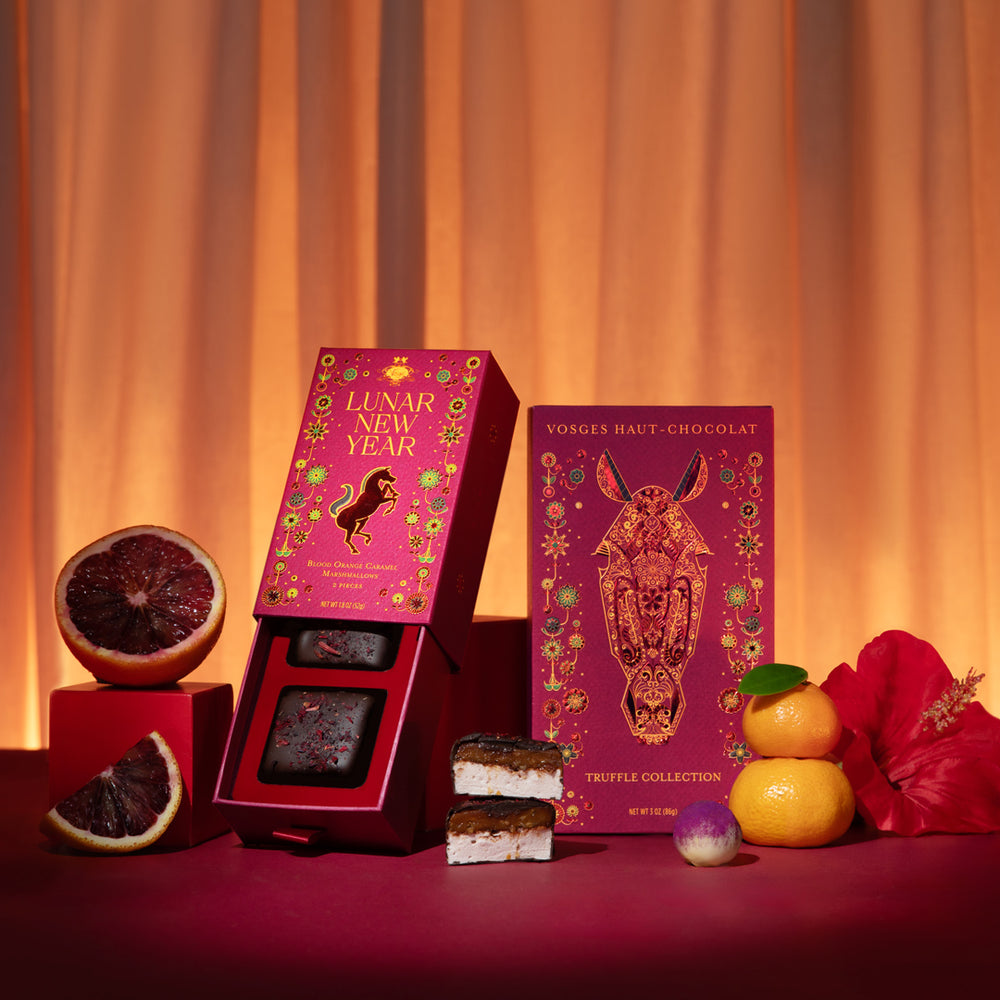 Lunar New Year The Year of the Horse gift tower with magenta boxes and assorted chocolates among citrus fruit