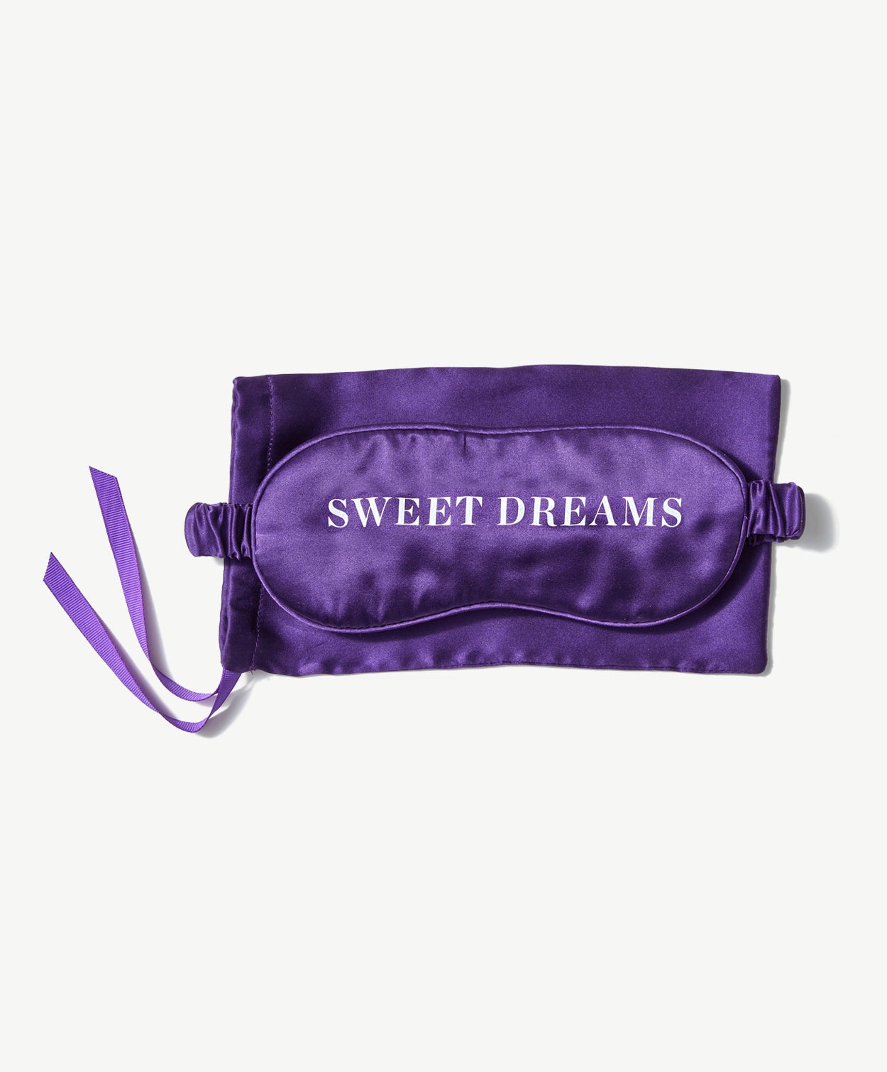Vosges Haut Chocolat purple silk sleep mask on top a matching storage bag with a purple ribbon on a light grey background.