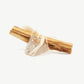 A Palot Santo stick tied to a transparent crystal with white thread string on a white background.