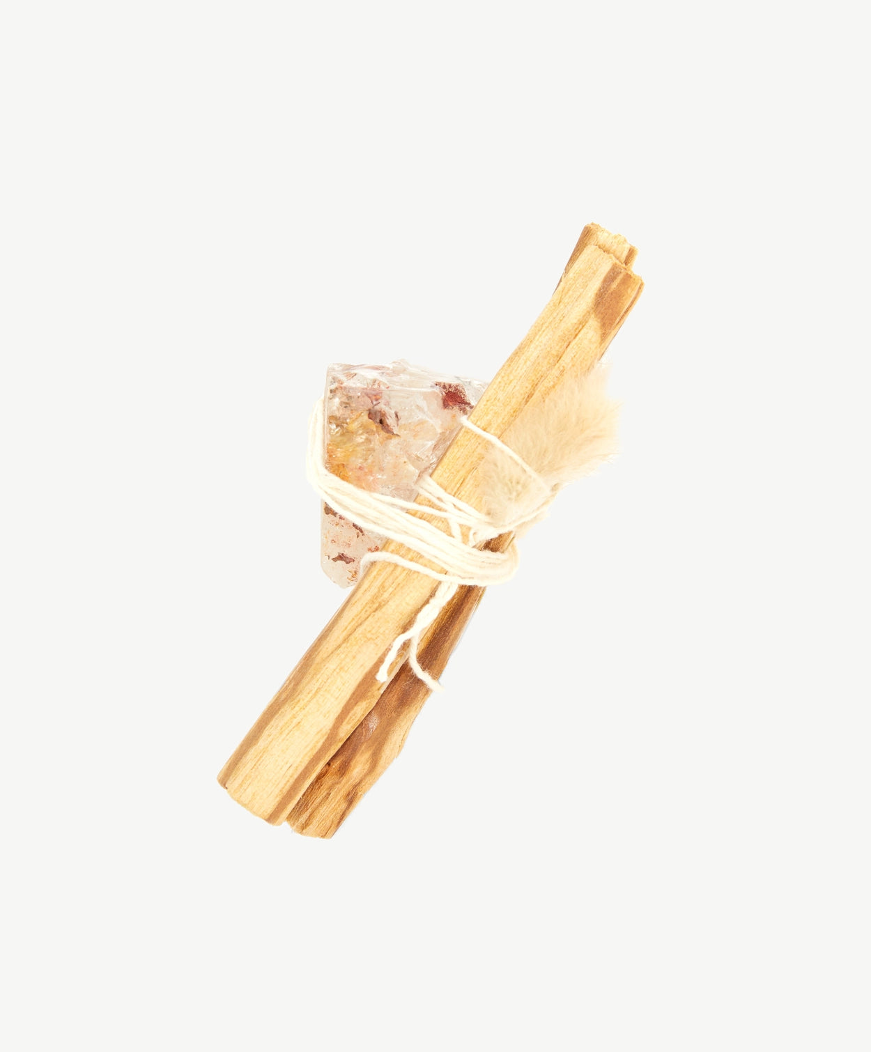 Palo Santo stick bundled to a transparent crystal with white thread string on a white background.
