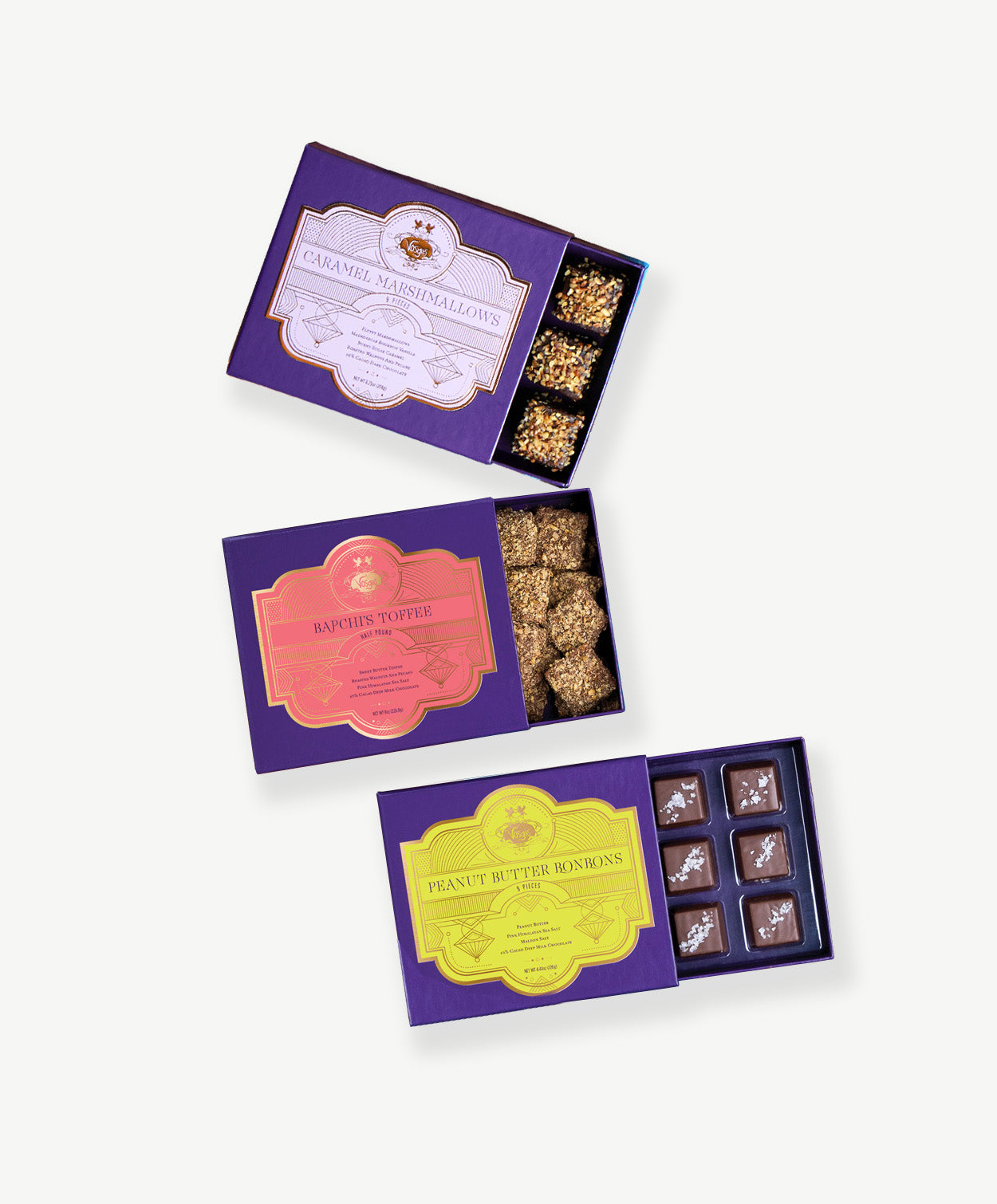 Three open boxes of Vosges Chocolate showing toffee, peanut butter bonbons and caramel marshmallows.