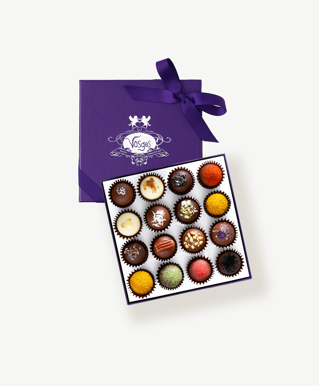 Open box of chocolate tied with a purple ribbon.  Vosges Haut-Chocolat Exotic Truffles 16 pieces Truffle Collection on white background.