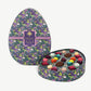 An egg shaped chocolate box decorated in bright purple and green dragons displaying a colorful collection of Vosges Chocolate truffles on a white background. 