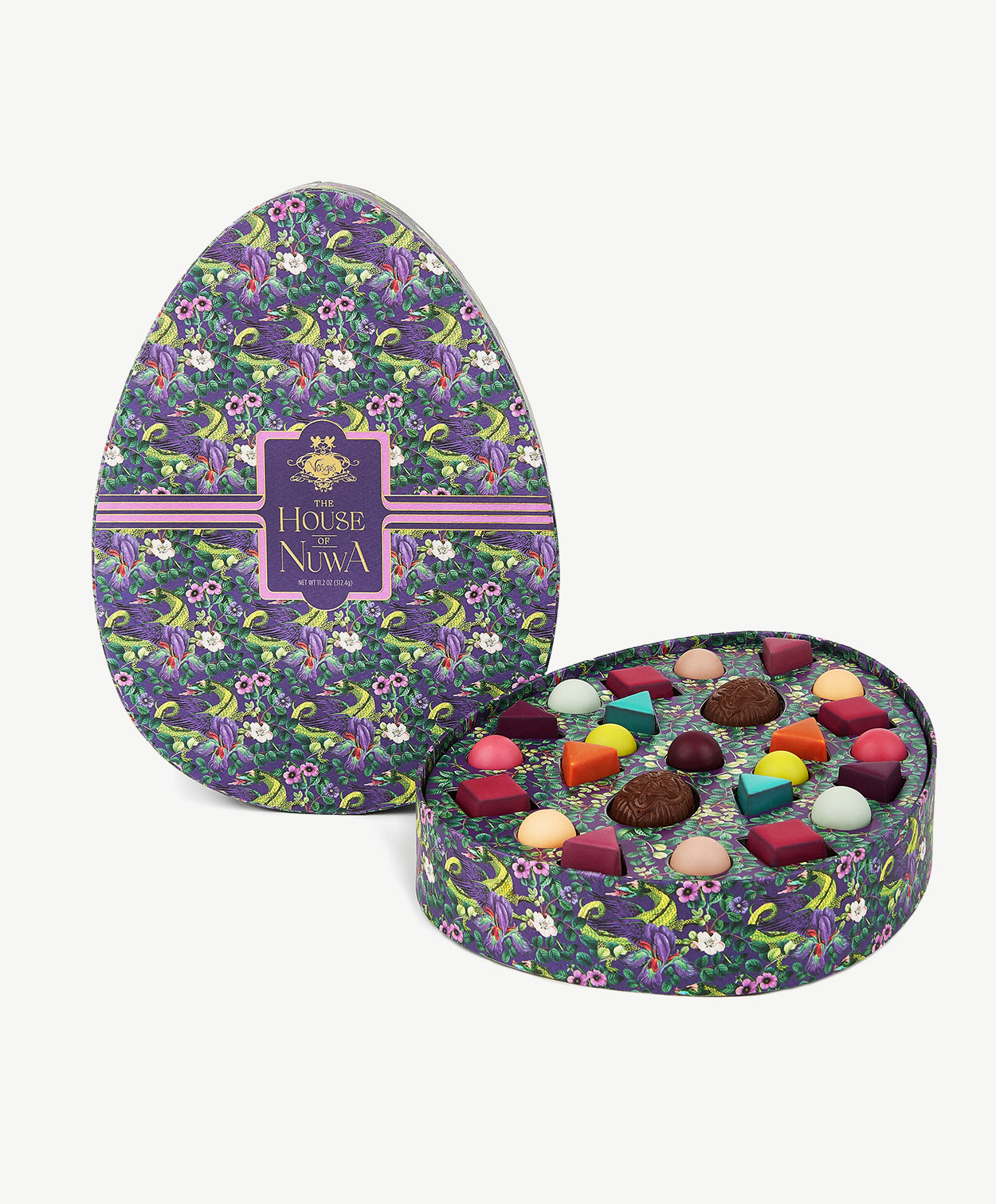 An egg shaped chocolate box decorated in bright purple and green dragons displaying a colorful collection of Vosges Chocolate truffles on a white background. 