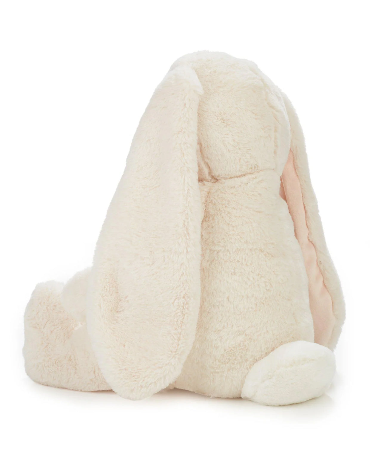 An enormous soft, plush white rabbit with long floppy ears sits upright on a white background viewed from behind.