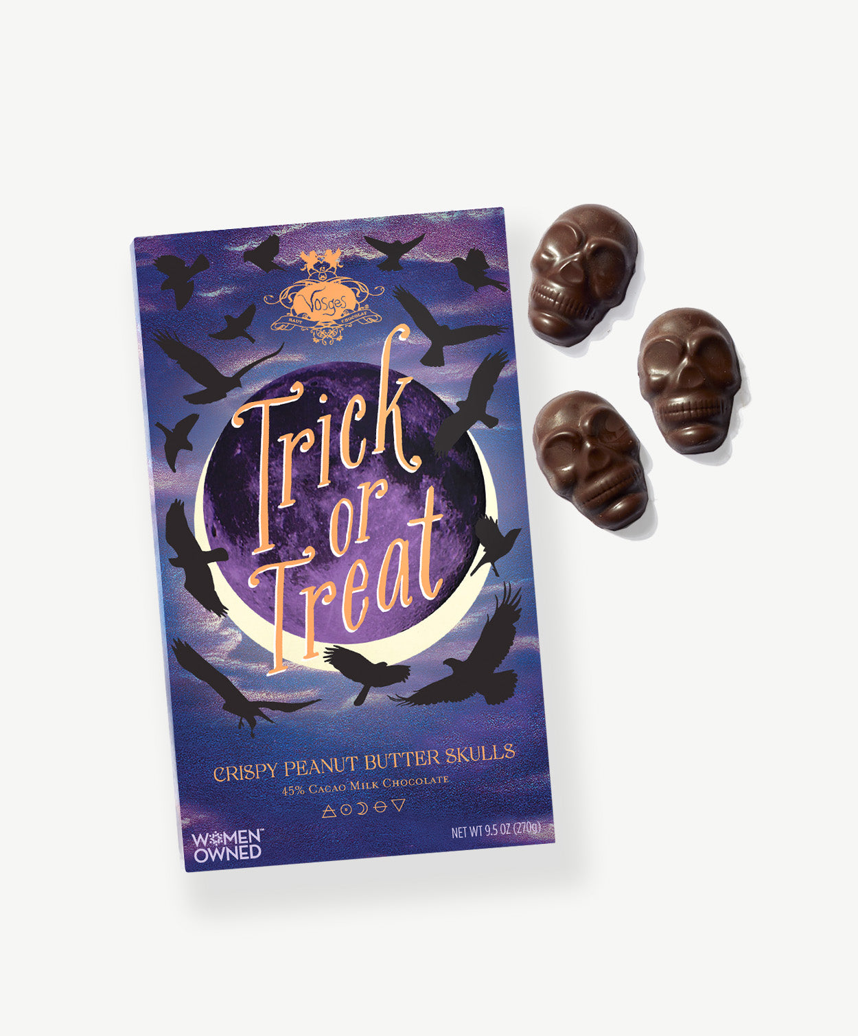 Chocolate Peanut Butter Skulls sit beside a purple and blue box decorated with the silhouettes of birds reading, "Trick or Treat" lay on a light grey background.