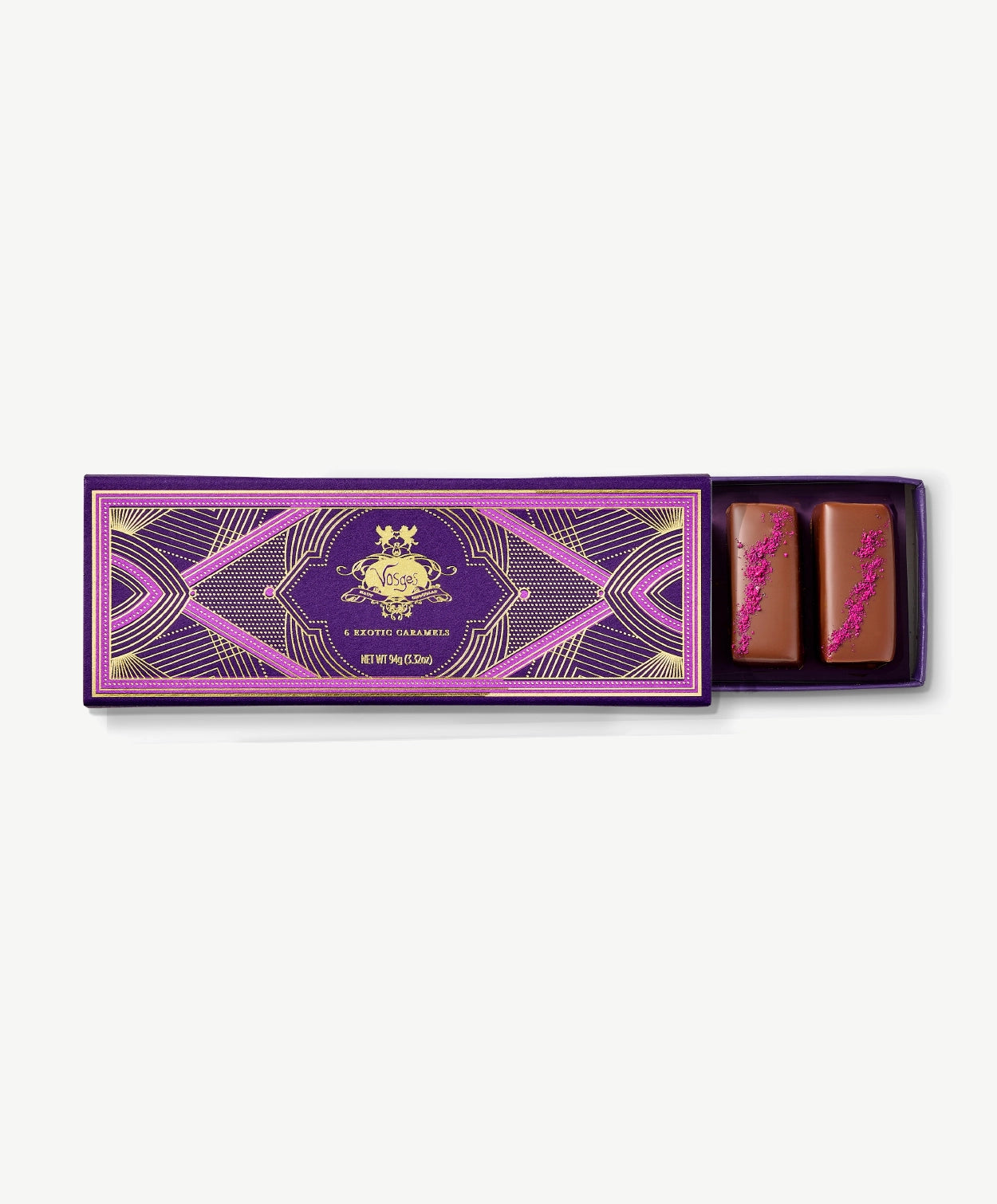 Purple Vosges Chocolate box opened revealing two chocolate covered caramels topped with red Hawaiian sea salt on a grey background.