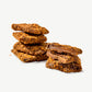 Two small stacks of buttery Vosges Gingerbread Toffee coated in Speculoos cookie crumble on a white background.