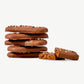 A small stack of Vosges Chocolate dipped Belgian Speculoos Cookies adorned with sprinkles on a white background.