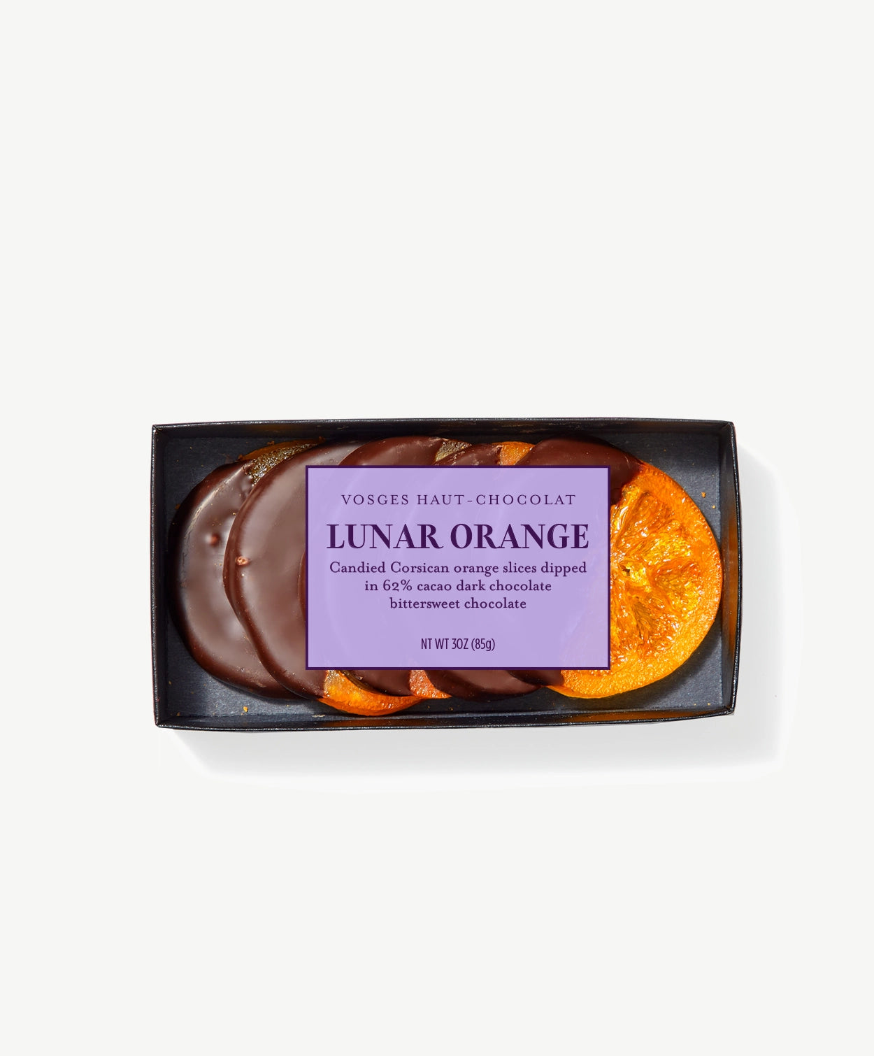 Several crystalized candied orange slices dipped in Vosges chocolate in a clear package bearing a light purple label on a grey background.